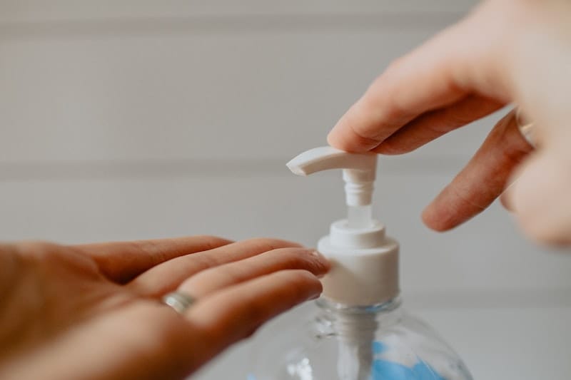 Hands of a woman using a sanitizer