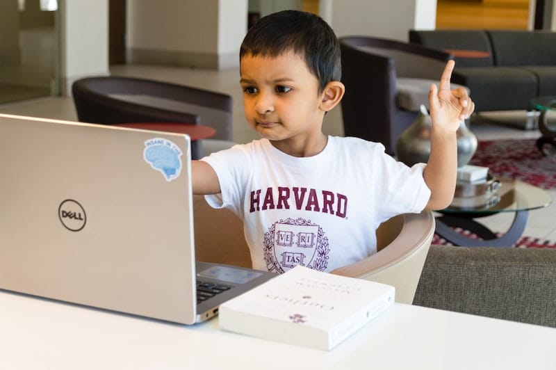 Niño con la mano levantada para hacer una pregunta